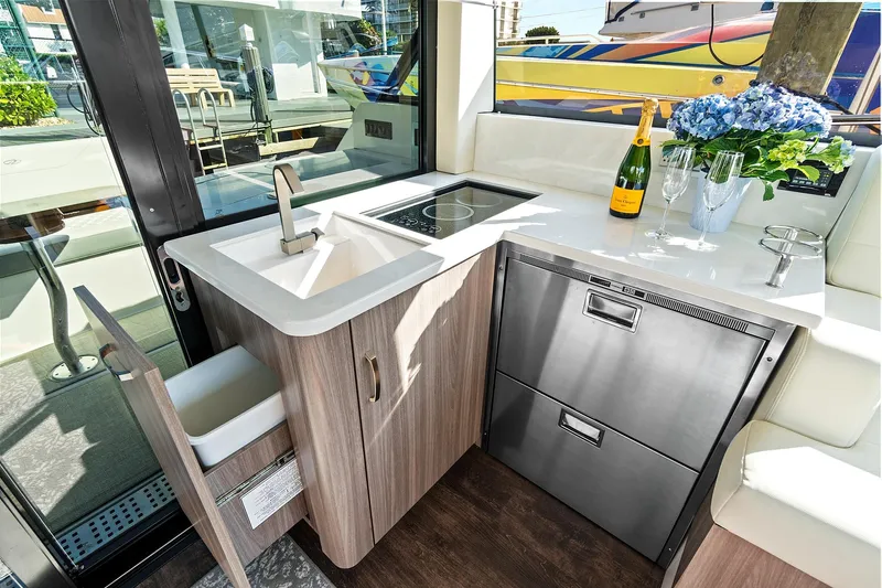 "seadancer" Yacht Photos Pics Modern kitchen area in 2022 Regal 38 XO yacht with sink, stove, and stainless steel appliances.