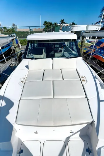 "seadancer" Yacht Photos Pics 2022 Regal 38 XO yacht with spacious sunbathing deck, docked under clear blue sky.