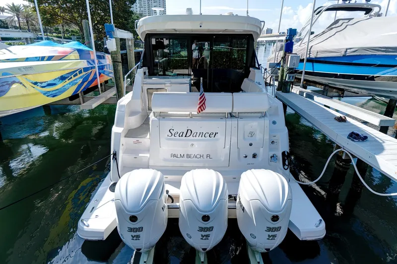 "seadancer" Yacht Photos Pics 2022 Regal 38 XO boat docked, featuring triple outboard engines and "SeaDancer" nameplate.