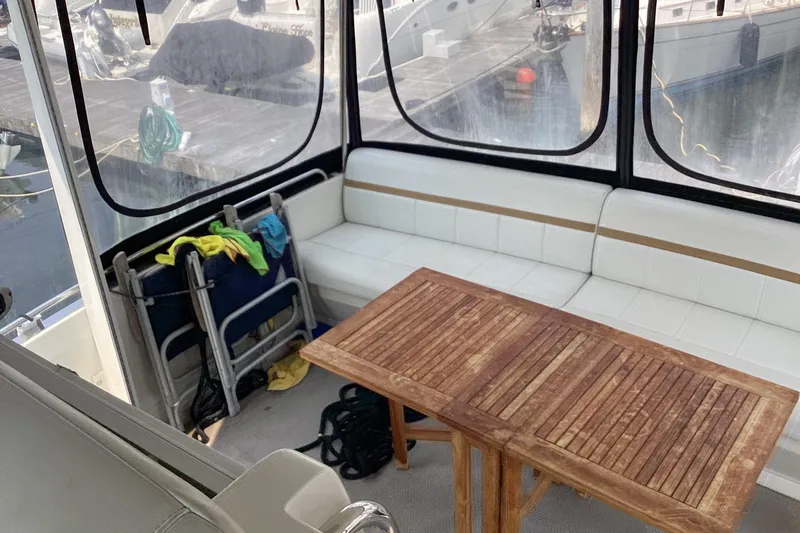 Fun Coupons Yacht Photos Pics 2005 Carver 41 Cockpit Motor Yacht interior with wooden table and white seating.