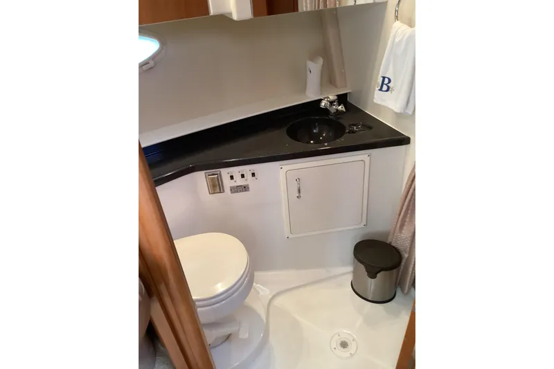 Fun Coupons Yacht Photos Pics 2005 Carver 41 Cockpit Motor Yacht bathroom with sink, toilet, and storage cabinet.