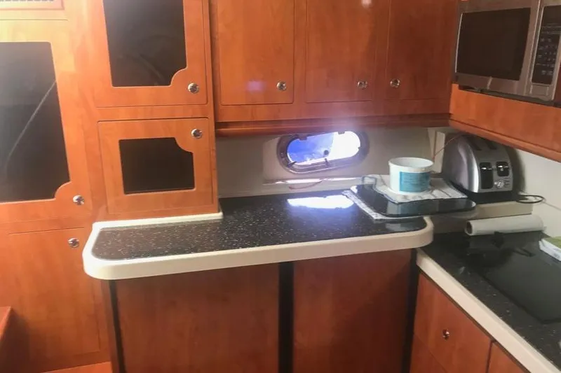  Yacht Photos Pics 2007 Four Winns 278 Vista boat interior with wooden cabinets and kitchenette.