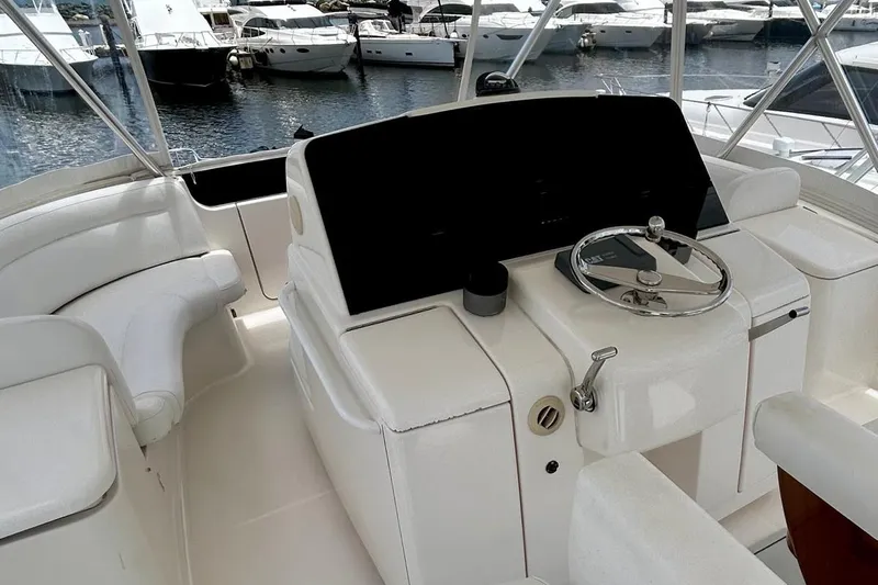Redeye Yacht Photos Pics Interior view of 2012 Tiara Yachts 48 CNV helm with white seating and steering wheel.