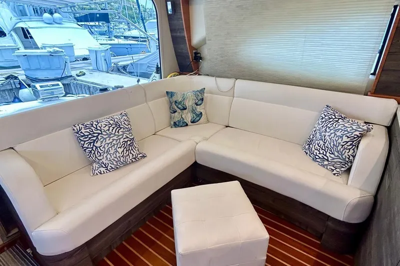 Redeye Yacht Photos Pics Luxurious interior of 2012 Tiara Yachts 48 CNV with white seating and decorative pillows.