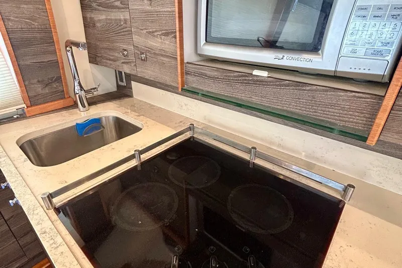 Redeye Yacht Photos Pics Modern kitchen area in a 2012 Tiara Yachts 48 CNV, featuring a sink and microwave.