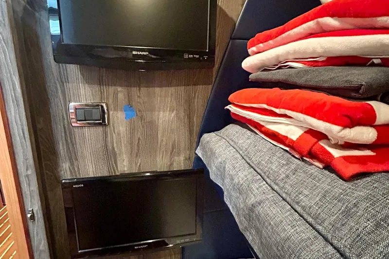 Redeye Yacht Photos Pics Interior of 2012 Tiara Yachts 48 CNV with TVs and folded blankets.