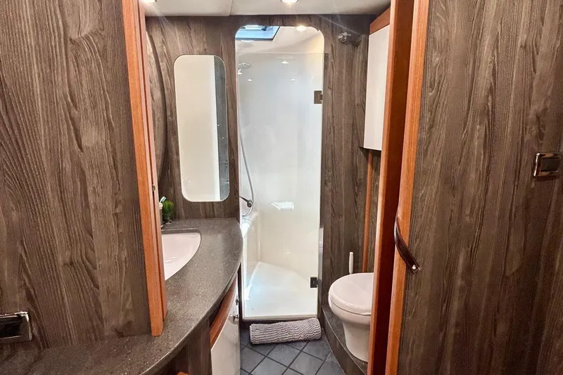 Redeye Yacht Photos Pics Luxurious bathroom in 2012 Tiara Yachts 48 CNV with wood paneling and modern fixtures.