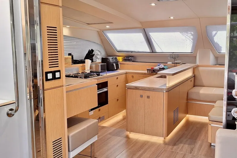 Emmanuel Yacht Photos Pics Luxurious 2023 Privilege Signature 510 yacht interior with modern kitchen and seating area.