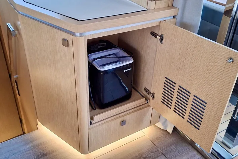 Emmanuel Yacht Photos Pics Modern kitchen cabinet with open door revealing a compact appliance inside.