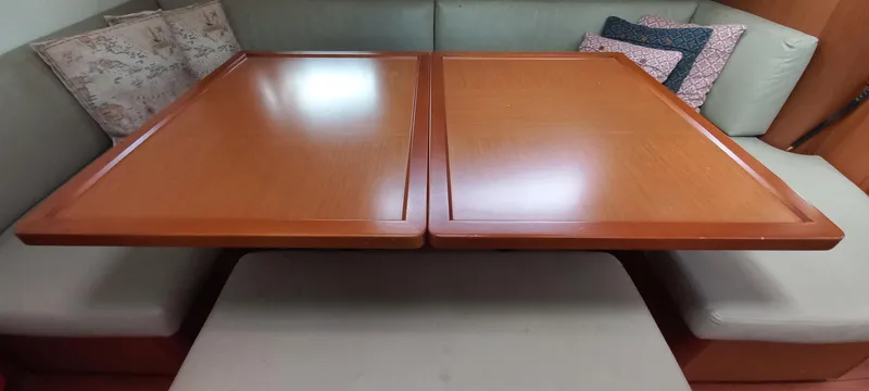 Lady Mys Yacht Photos Pics Interior dining area of 2013 Beneteau Oceanis 48 yacht with wooden table and cushioned seating.