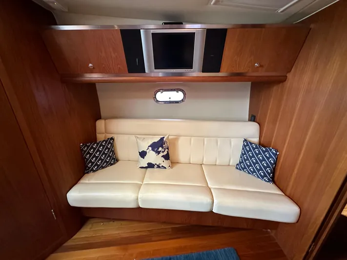  Yacht Photos Pics 2005 Tiara Yachts 3600 Sovran interior with white sofa, nautical pillows, and wall-mounted TV.