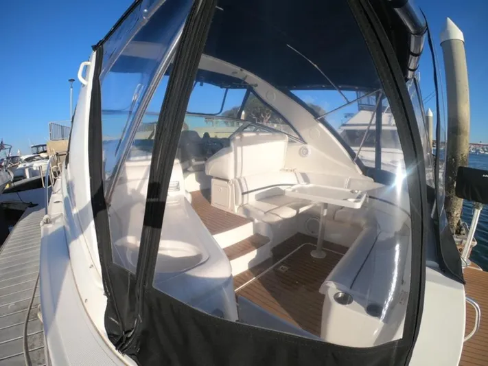 Grand Cru Yacht Photos Pics 2005 Cruisers Yachts 340 Express interior with seating and table, docked under clear blue sky.