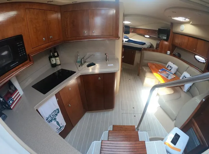 Grand Cru Yacht Photos Pics 2005 Cruisers Yachts 340 Express interior with kitchen, seating area, and wooden cabinetry.