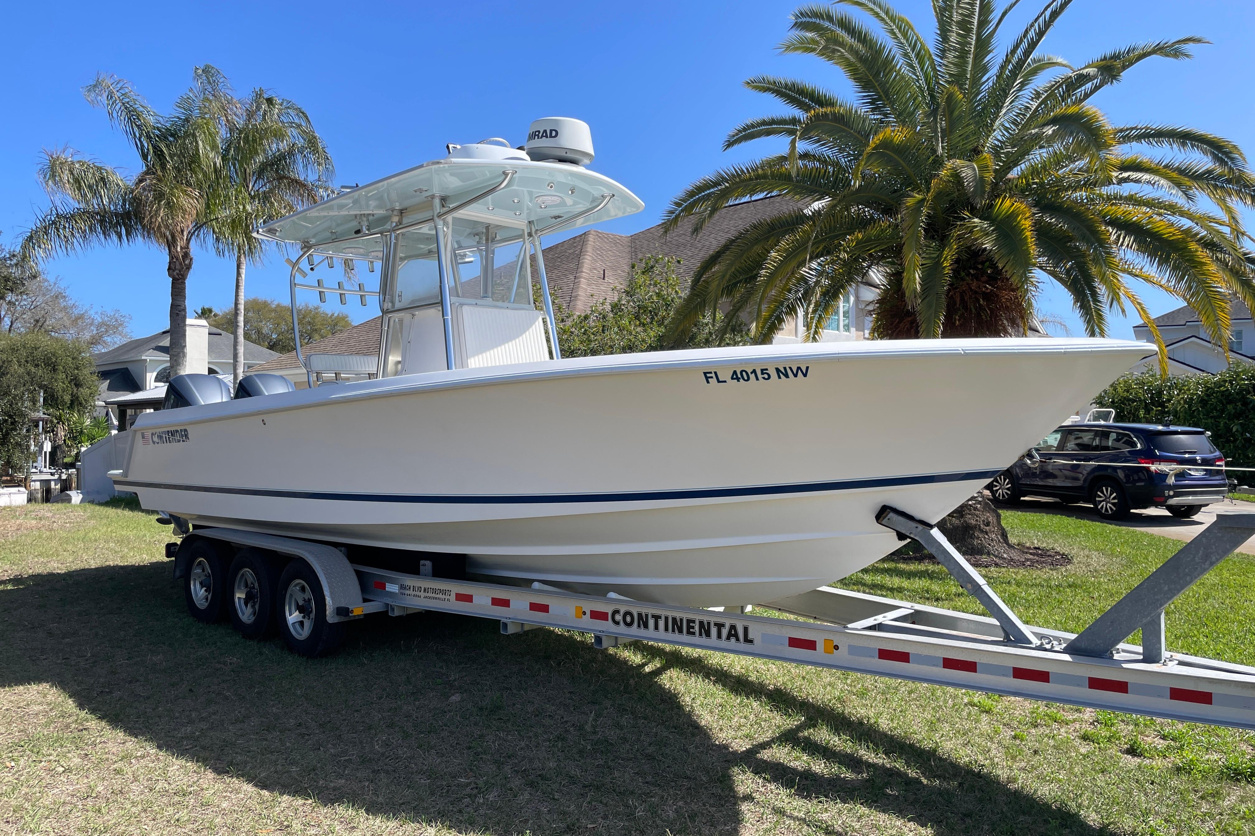 2008 Contender 27 Tournament boat on trailer, parked near palm trees.