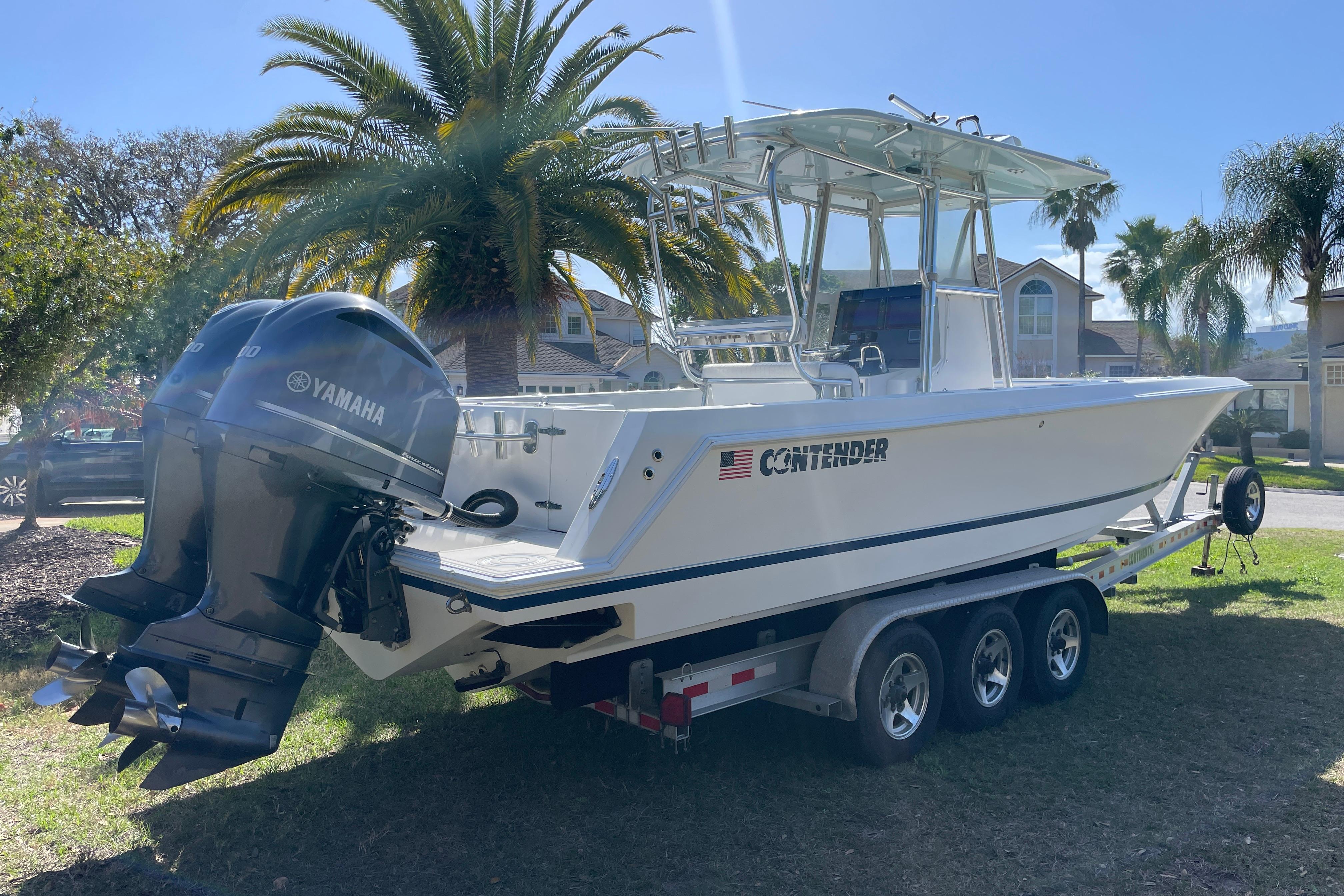 2008 Contender 27 Tournament boat with Yamaha engines on a trailer, parked outdoors.