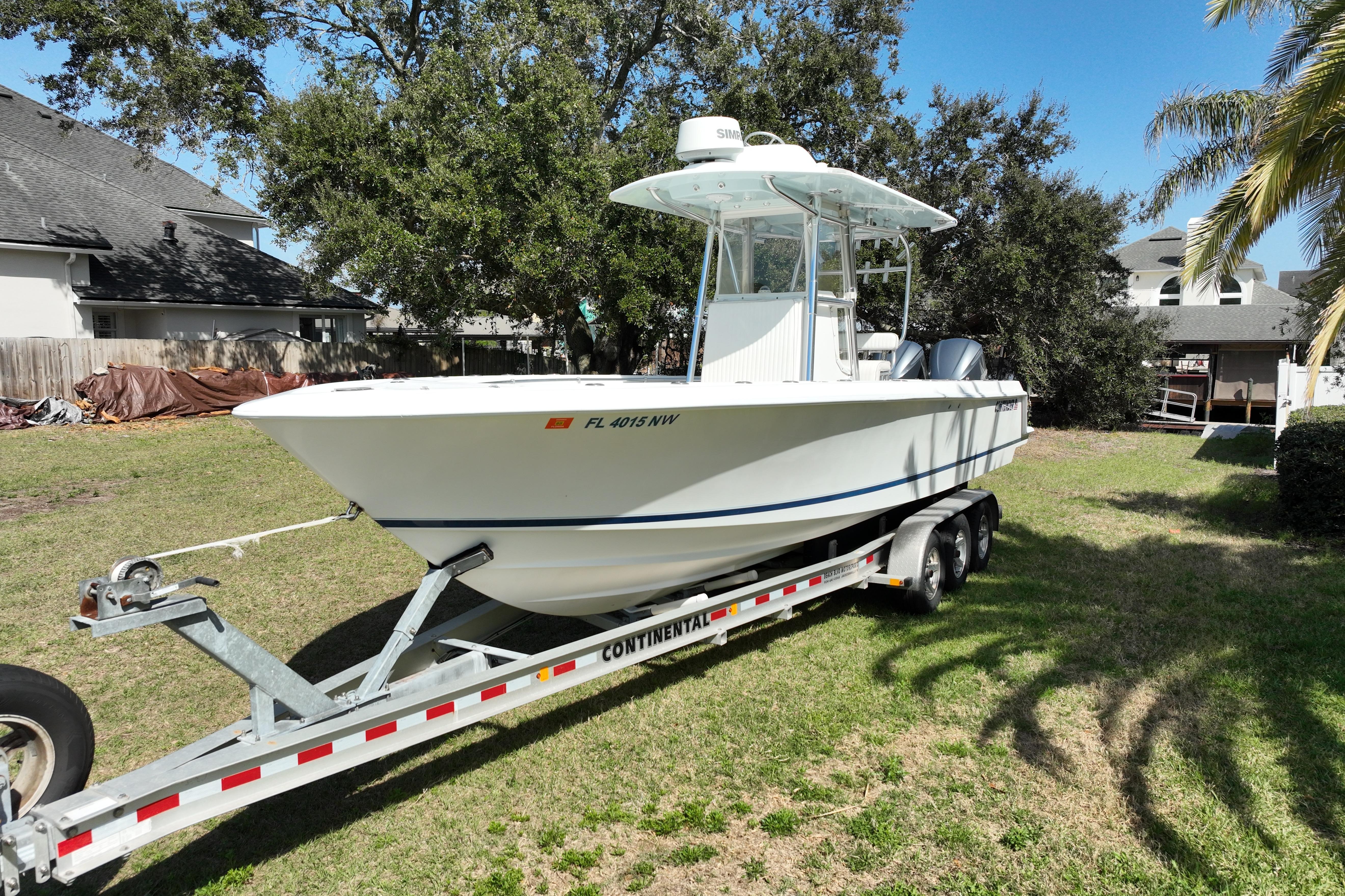 2008 Contender 27 Tournament boat on trailer in residential yard.