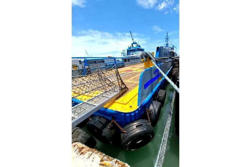  Yacht Photos Pics Custom Offshore Crew Vessel, 2008, docked with blue and yellow deck, under clear sky.