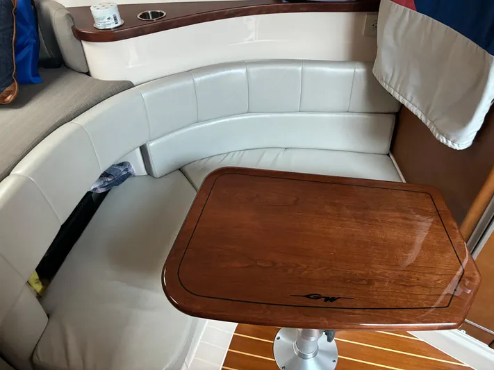  Yacht Photos Pics 2014 Grady-White Express 330 interior with curved seating and wooden table.