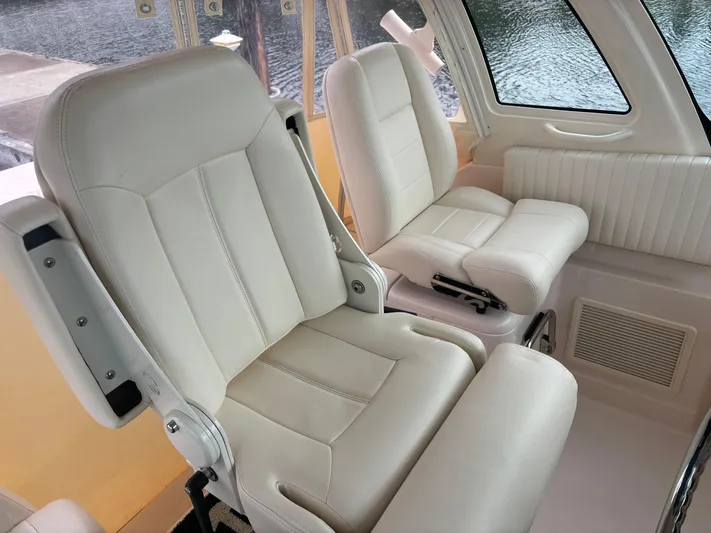  Yacht Photos Pics 2014 Grady-White Express 330 interior with plush white seating and window view.