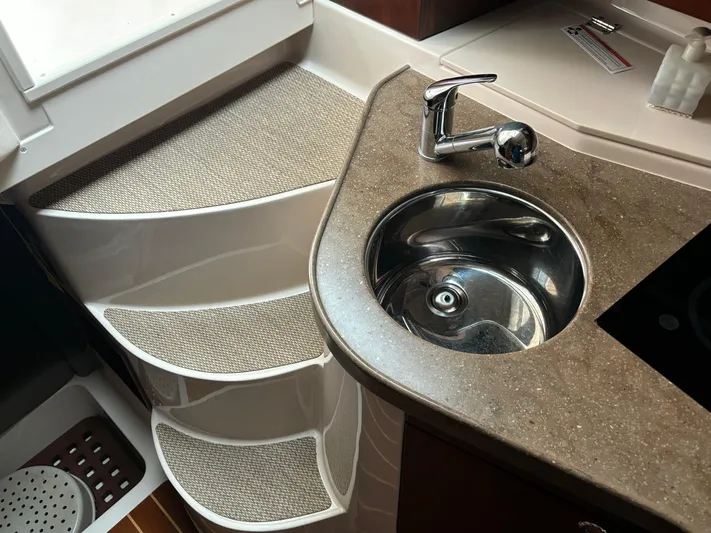  Yacht Photos Pics Compact kitchen area in 2014 Grady-White Express 330 boat with sink and steps.