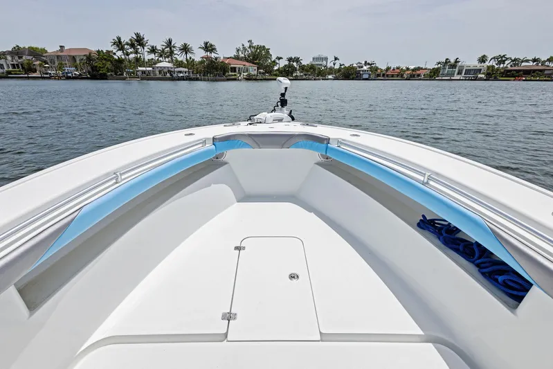  Yacht Photos Pics 2016 Yellowfin 26 Hybrid boat on calm water, featuring spacious deck and sleek design.