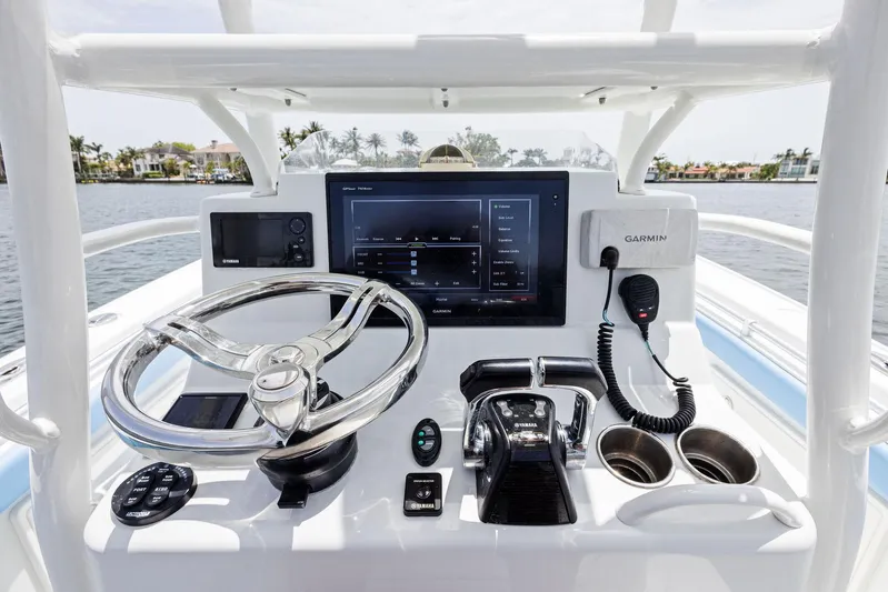  Yacht Photos Pics 2016 Yellowfin 26 Hybrid boat dashboard with steering wheel, Garmin electronics, and control panel.