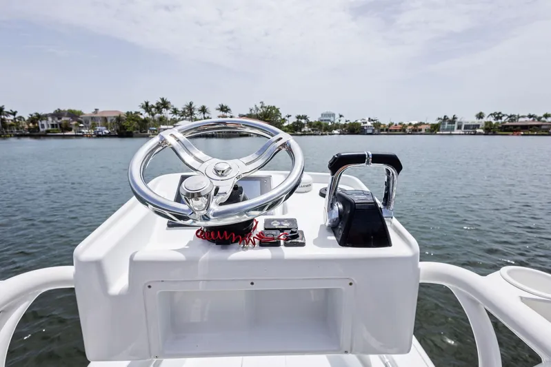  Yacht Photos Pics Steering console of 2016 Yellowfin 26 Hybrid boat on calm water.
