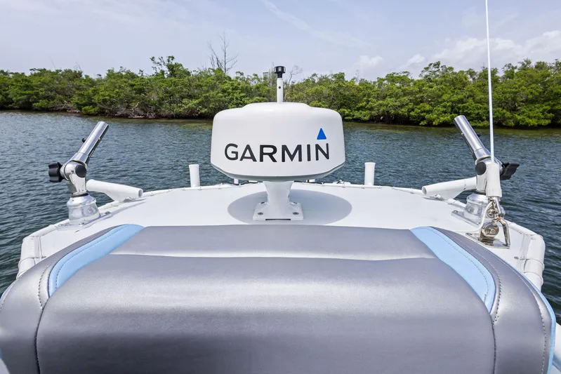  Yacht Photos Pics 2016 Yellowfin 26 Hybrid boat with Garmin equipment, surrounded by lush greenery.