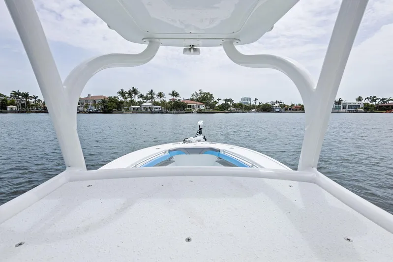  Yacht Photos Pics 2016 Yellowfin 26 Hybrid boat on calm water with coastal view.