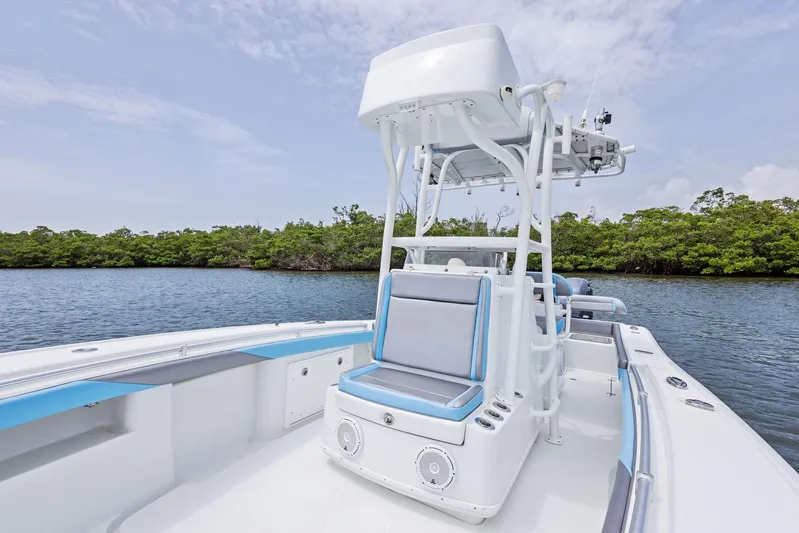  Yacht Photos Pics 2016 Yellowfin 26 Hybrid boat on calm water, featuring sleek design and comfortable seating.