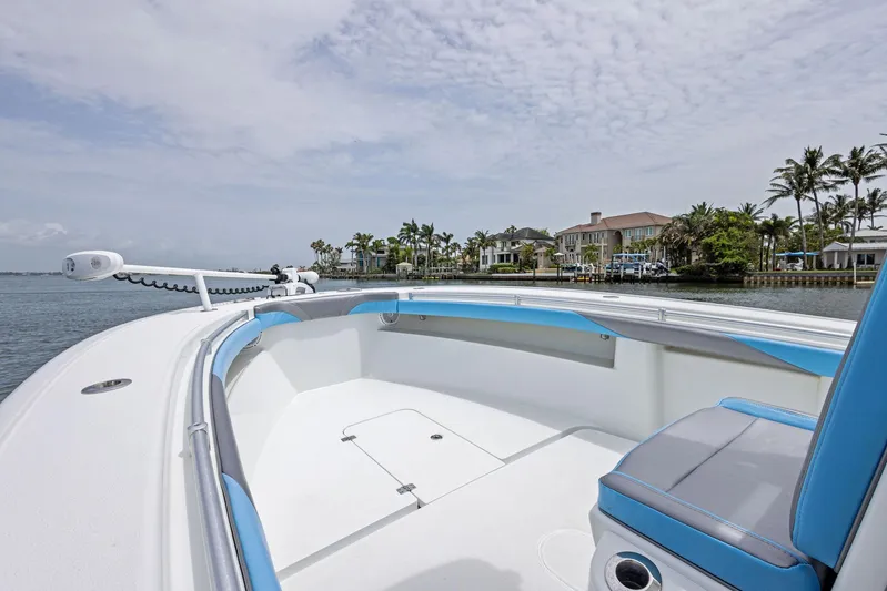  Yacht Photos Pics 2016 Yellowfin 26 Hybrid boat with blue accents, docked near waterfront homes.