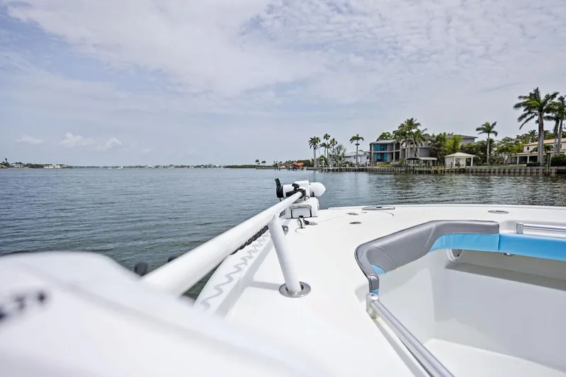  Yacht Photos Pics 2016 Yellowfin 26 Hybrid boat on calm water near coastal homes and palm trees.