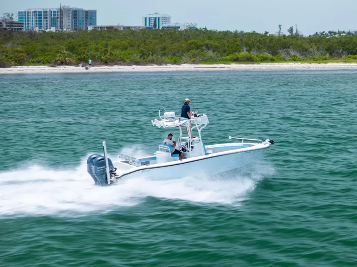  Yacht Photos Pics 2016 Yellowfin 26 Hybrid boat cruising near a scenic shoreline.