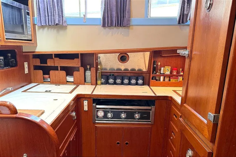 Summer Wind Yacht Photos Pics Galley kitchen in 1989 Grand Banks 46 Classic yacht with wood cabinetry and modern appliances.
