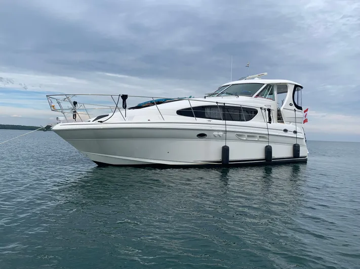  Yacht Photos Pics 2005 Sea Ray 390 Motor Yacht on calm water under cloudy sky.
