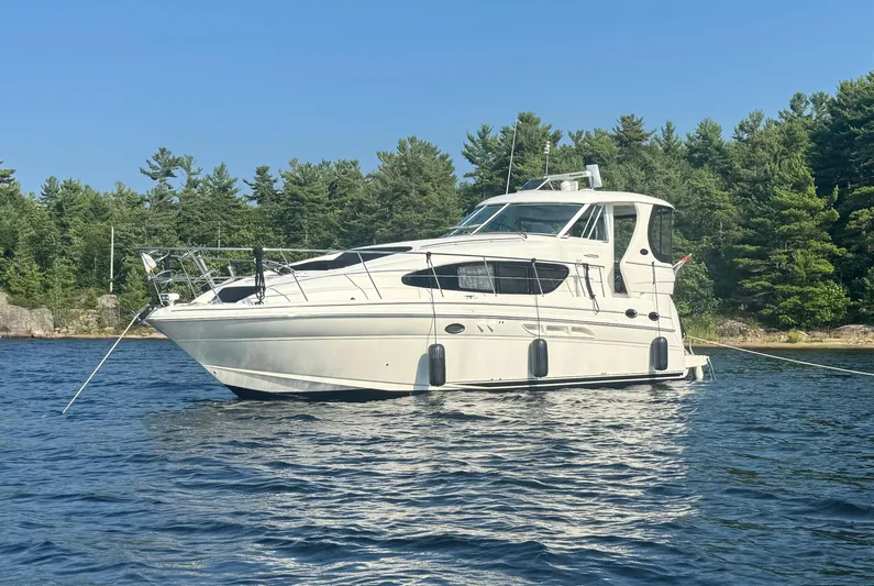  Yacht Photos Pics 2005 Sea Ray 390 Motor Yacht anchored on a serene lake with forested shoreline.