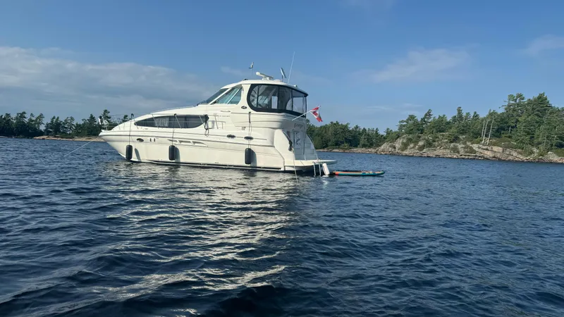  Yacht Photos Pics 2005 Sea Ray 390 Motor Yacht anchored on a serene lake with forested shoreline.
