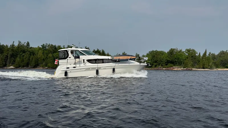  Yacht Photos Pics 2005 Sea Ray 390 Motor Yacht cruising on a lake with forested shoreline.