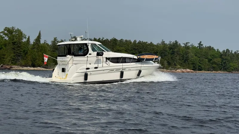  Yacht Photos Pics 2005 Sea Ray 390 Motor Yacht cruising on a lake with forested shoreline.