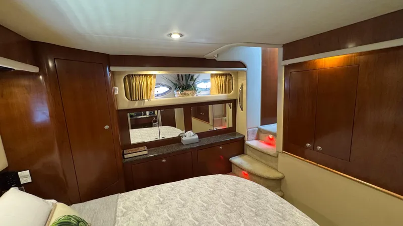  Yacht Photos Pics Luxurious interior of 2005 Sea Ray 390 Motor Yacht with wood paneling and cozy bedding.