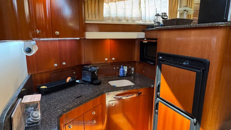  Yacht Photos Pics Luxurious kitchen interior of 2005 Sea Ray 390 Motor Yacht with wooden cabinetry.