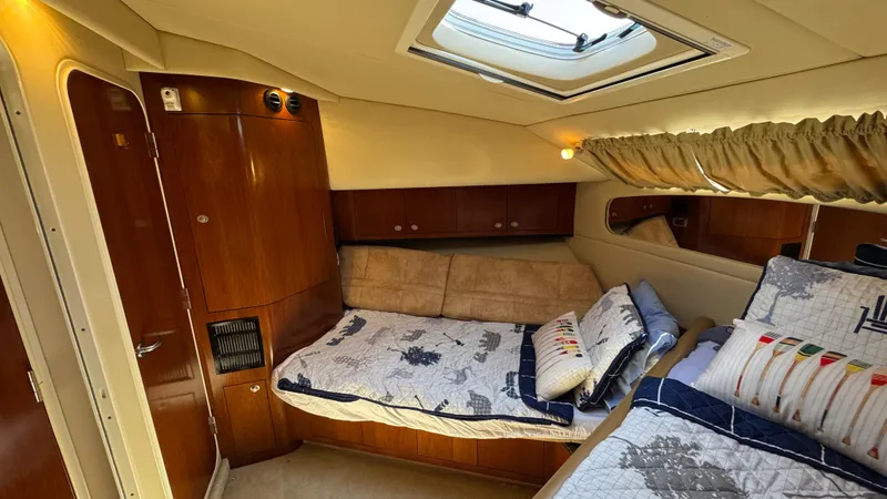  Yacht Photos Pics Interior cabin of 2005 Sea Ray 390 Motor Yacht with cozy bedding and wooden cabinetry.