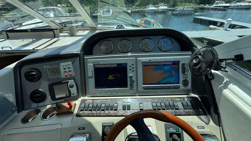  Yacht Photos Pics 2005 Sea Ray 390 Motor Yacht helm with navigation screens and controls, docked at marina.