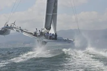  Yacht Photos Pics Sailing yacht CDK Technologies MOD70, 2011, cutting through waves with crew onboard.