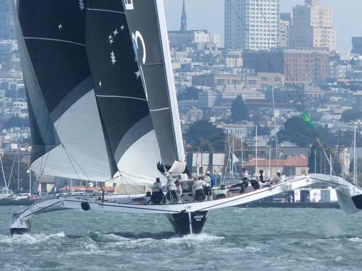  Yacht Photos Pics Sailing yacht CDK Technologies MOD70, 2011, navigating urban waters with cityscape backdrop.