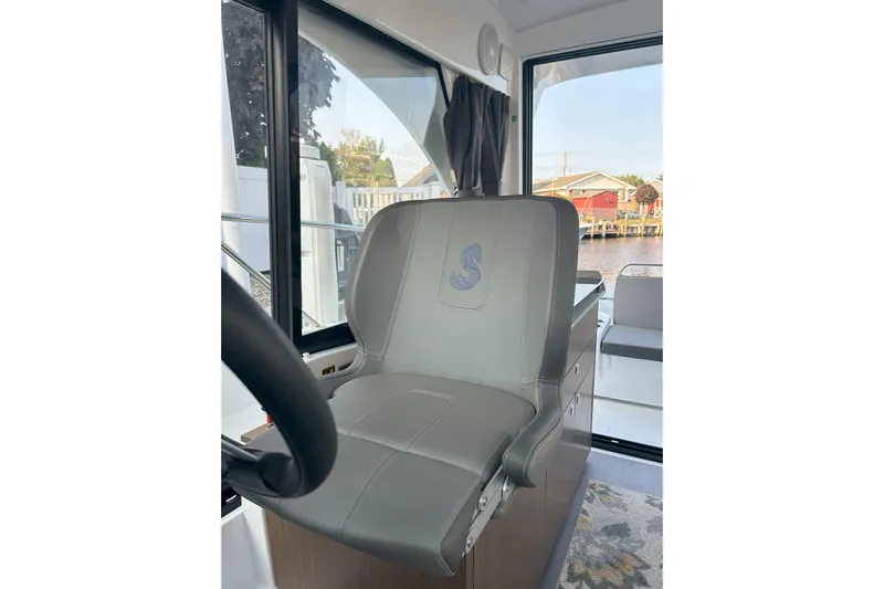  Yacht Photos Pics Captain's seat in 2024 Beneteau Antares 9 boat interior, featuring sleek design and waterfront view.