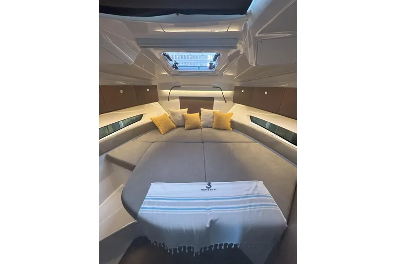  Yacht Photos Pics 2024 Beneteau Antares 9 cabin interior with cozy bedding and decorative pillows.
