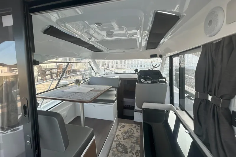  Yacht Photos Pics Interior of 2024 Beneteau Antares 9, featuring modern seating and dining area.