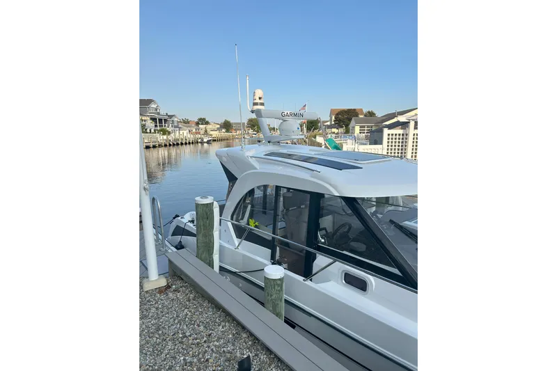  Yacht Photos Pics 2024 Beneteau Antares 9 docked at a marina, showcasing sleek design and modern features.
