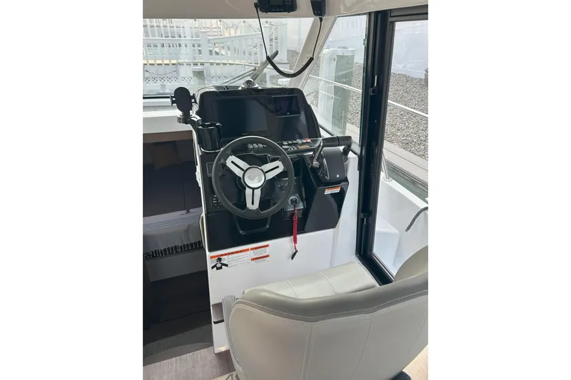  Yacht Photos Pics 2024 Beneteau Antares 9 helm station with steering wheel and controls.